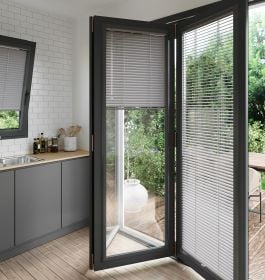 A grey coloured perfect fit blind on a set of anthracite bifold doors