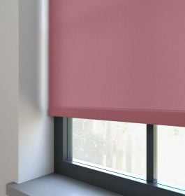 Our Burst Blushed Plum Roller blind in a living room window.